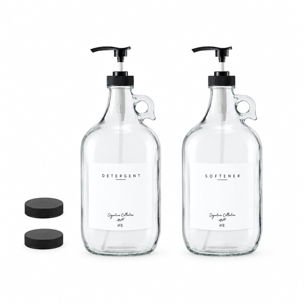 Two clear glass pump bottles with black caps and handles, labeled 'DETERGENT' and 'SOFTENER', shown on a white background with two black lid caps at the upper left.