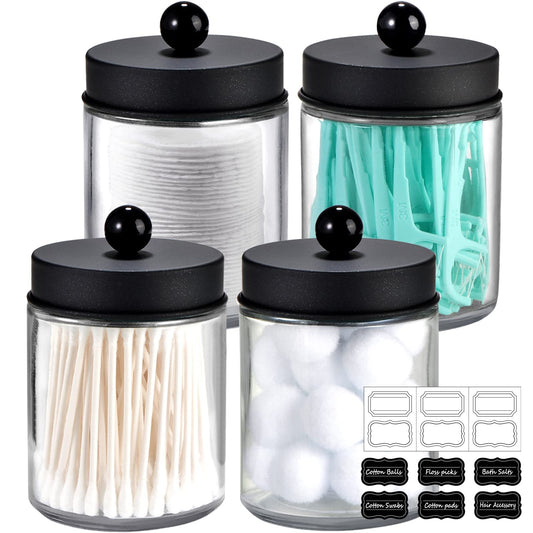 Set of four glass jars with black lids, each containing different items, on a white background.