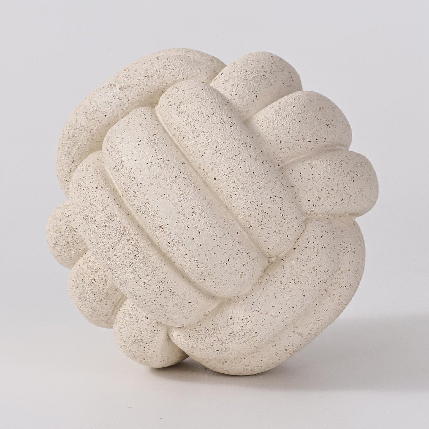 Decorative stone knot sculpture on a light gray background