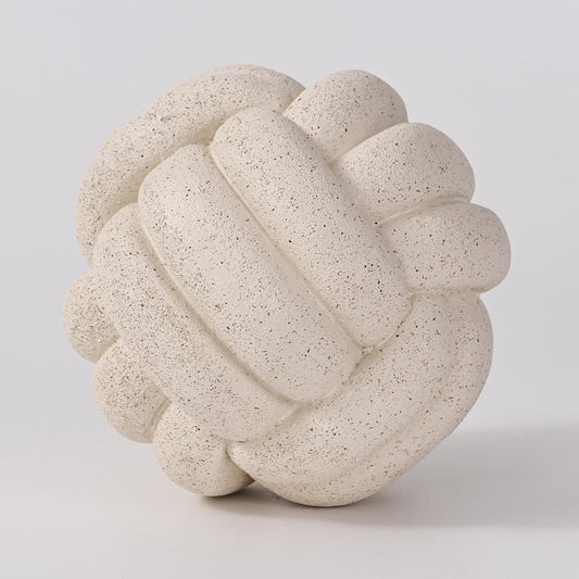 Decorative stone knot sculpture on a light gray background